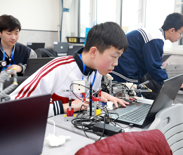 学生们手持一个“口袋乌龟然后将其放在涂有不同色彩的纸上